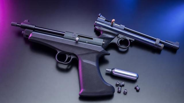 CO₂ pištole Diana Chaser a Crosman 2240 položené vedľa seba na pracovnom stole.