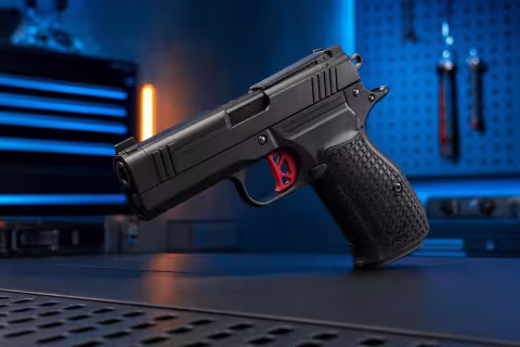 Dan Wesson DWX Compact OR bez zásobníka na tmavom pracovnom povrchu.