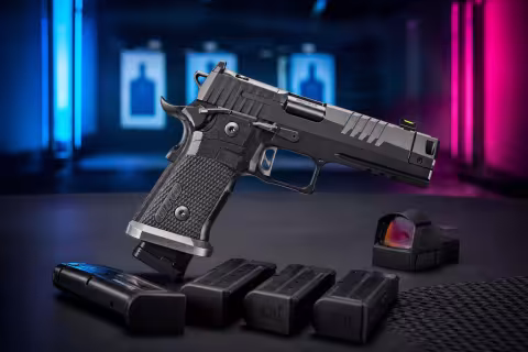 Čierna pištoľ SIG Sauer P211-GTO s kompenzátorom a zásobníkmi P320 na streleckom stole.