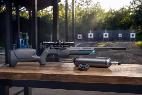 Vzduchovka Umarex Komplete NCR .22 s dusíkovou bombičkou a zásobníkom na streleckom stole.