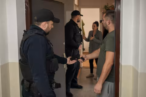 Policajti zaisťujú legálnu zbraň počas zásahu pri konflikte v bytovom dome.